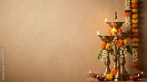 Diwali oil lamps with flowers and marigold garlands on a table with copy space