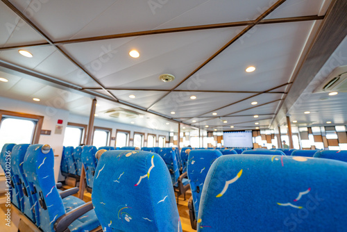 фотографія Rows of blue passenger seats inside a bright ferry cabin