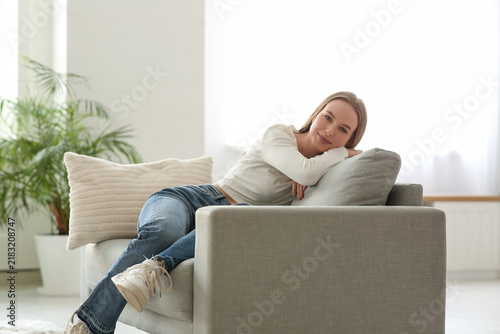 Young woman resting on sofa in living room