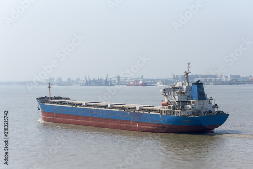 Obraz na płótnie Bulk cargo vessel navigating through an industrialized section of the Yangtze Ri