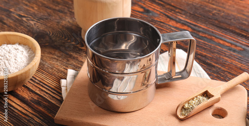 фотографія Baking and culinary preparation, metal flour sifter with wooden scoop and bowl o