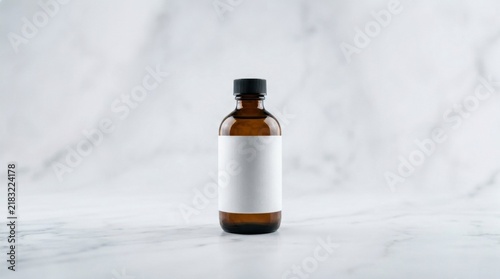 Amber glass dropper bottle with blank white label for product branding, showcasing minimalist packaging design on an elegant white marble surface