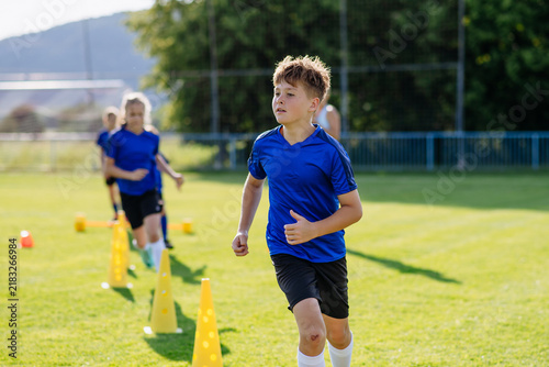 Obraz na plátně Young athletes training footwork and coordination on soccer field