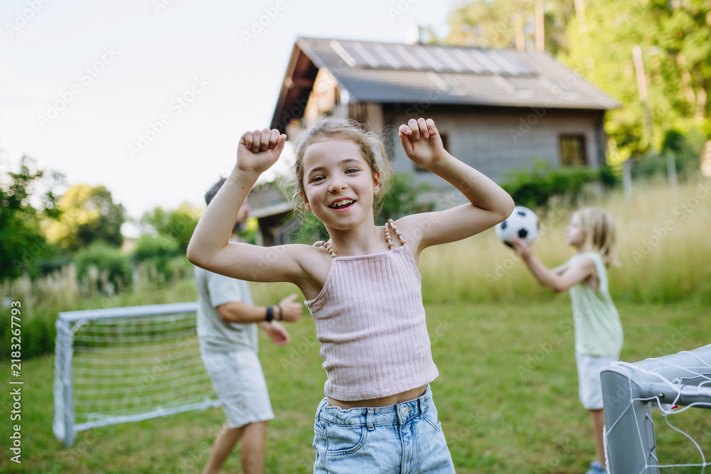 Obraz premium Girl enjoying football game outdoors during summer afternoon.