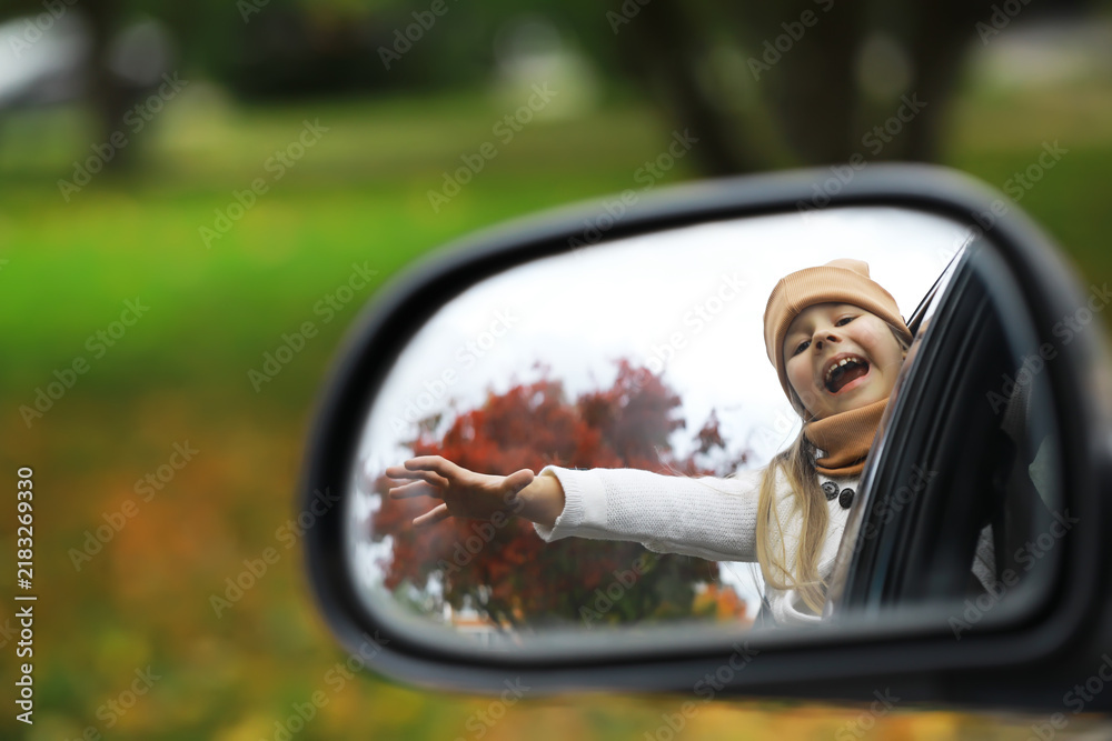 Obraz premium Joyful Child Enjoying Autumn Ride Reflected in Car Side Mirror