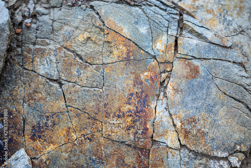 Cuadro en lienzo Close-up of fractured sandstone rock with gray, orange and rusty mineral staining, showing natural cracks, weathering and geological texture exposed during slope terracing