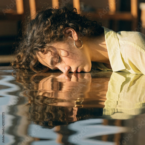 Surreal Woman Resting on Reflective Surface with Distorted Reflection