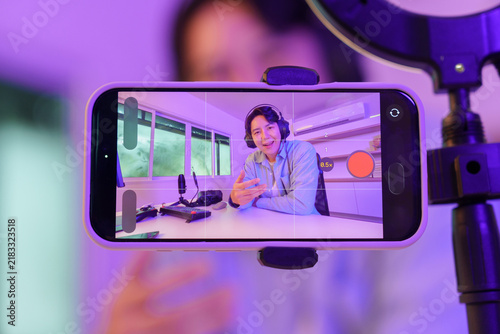 Asian male content creator live streaming video on smartphone for social media vlog