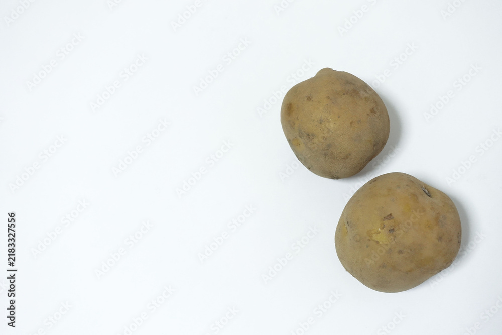 Fototapeta premium Two potatoes placed to the right on a white surface, food photo