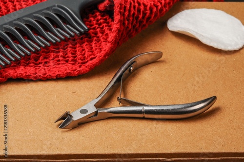 Quadro su tela Manicure tools including cuticle nippers, comb, and cotton pad on a textured sur