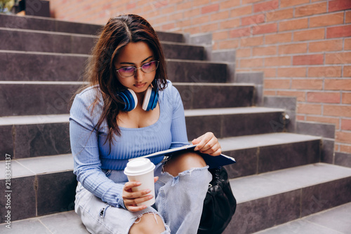 Foto Young student reading a book and drinking coffee