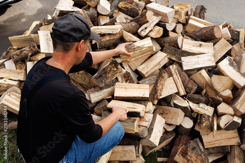 Young Man Carrying Firewood to Storage, Preparing for Winter