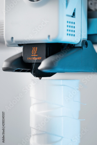 3D printer head printing a detailed white plastic component