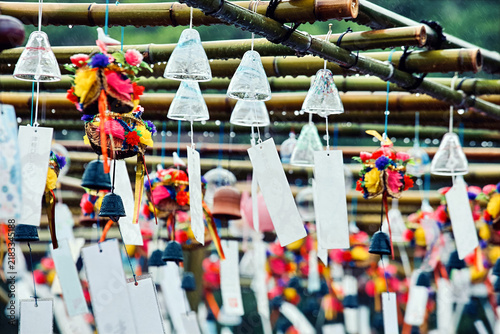 Foto Traditional Japanese Glass Wind Chimes Furin Hanging on Bamboo Frame Outdoors