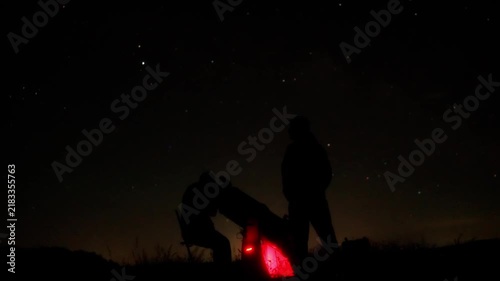 Amateur astronomers observing stars, planets, Moon and other celestial objects with a telescope in nature. Time-lapse video.