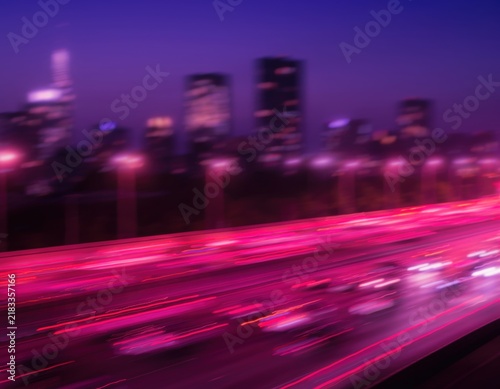 Motion blur of city traffic lights on a highway at night with skyscrapers in the background