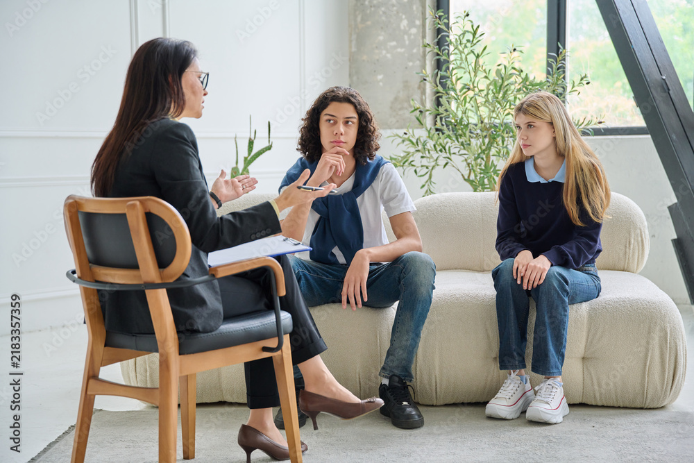 Fototapeta premium School psychologist counseling teenagers in office