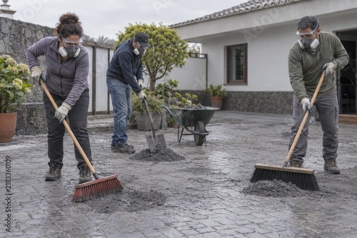 Residents Safely Cleaning Damp Volcanic Ash from a Courtyard