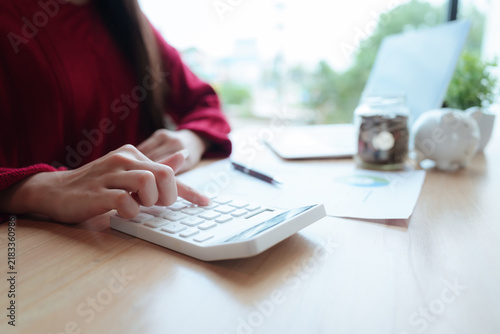 Young woman planning her personal finances, reviewing a budget and savings goals while working on a laptop at home.