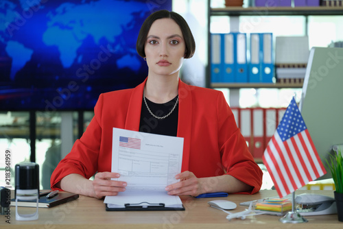 Konstfotografi Serious female visa counselor holds application form in office