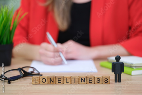 Принти на полотні A person in a red blazer sits at a wooden table, writing notes