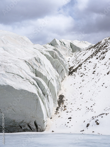 Принти на полотні Snowy Glacier Landscape with Crevasses and Rocky Mountain Slopes
