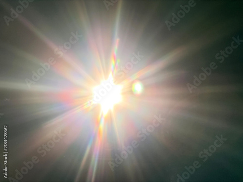 фотографія Bright sun flare with rainbow diffraction rays