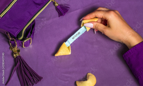 Female hand opens a fortune cookie with a no future message