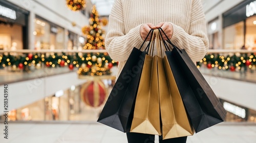 Hands Holding Black and Gold Shopping Bags in Mall on Black Friday