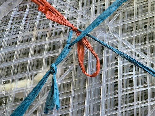 Foto Transparent Plastic Grid Mesh Bound with Blue and Orange Raffia String