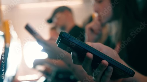 Close up smartphone in hand of unrecognizable traveler with passengers inside airplane. Checking email and online notifications during flight. Mobile connectivity and modern air travel concept