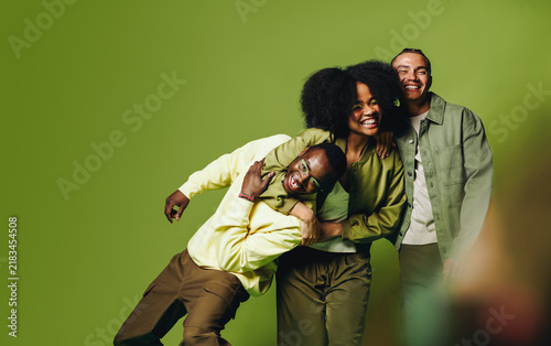 Friends posing together in playful studio portrait with happy young people and urban style