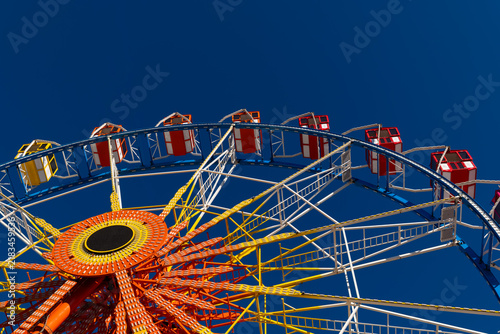 Ferris wheel stands tall against a clear blue sky at a fairground