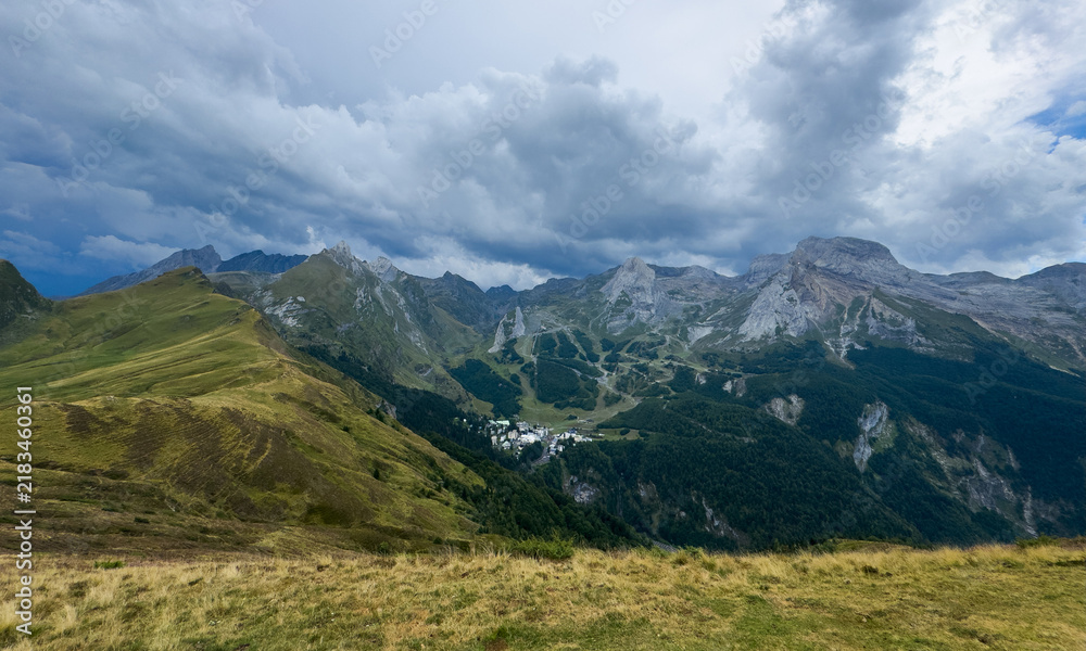 Obraz premium Mountain landscape scenic view, in high-altitude valley with forested slopes and rocky peaks, with mountains, valley, forested slopes, rocky peaks, with green, gray accents.