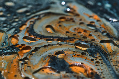 Konstfotografi Close up abstract liquid background featuring shiny oil droplets over orange and blue paint flows