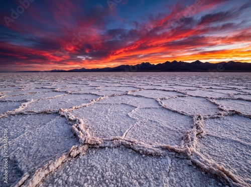 Dramatic sunset over salt flats, cracked salt crust texture, majestic desert landscape at twilight
