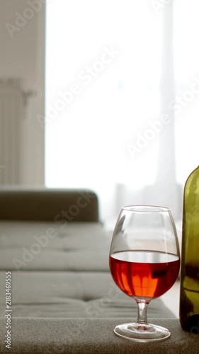 ALCOHOLISM: Empty room and a bottle of wine by the couch