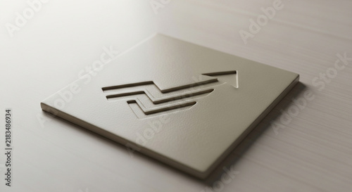 A metallic tile displaying an upward trending growth graph symbol rests steadily upon a wooden desk surface within a professional corporate office environment highlighting financial progress