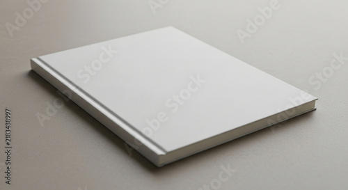 A blank hardcover publication lies flat upon a neutral surface, showcasing its empty front cover ready for custom branding designs and creative publishing layout presentations