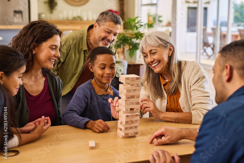 Happy multiethnic generation family playing with block removal game