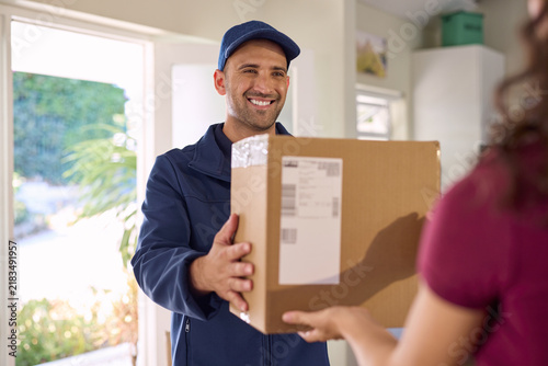 Smiling and friendly delivery man delivering parcel