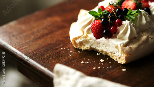 Pavlova dessert with strawberries blackberries and whipped cream closeup