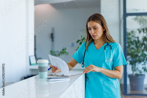 Female medical professional reviewing patient charts at clinic