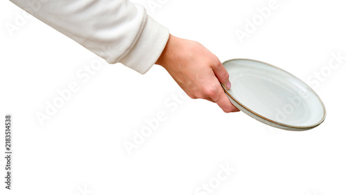 Woman hand holding empty ceramic plate isolated on transparent background. Waitress or housewife offering tableware. Dining service concept, food presentation and kitchen utensil object.