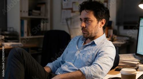 Tired corporate employee leaning back in office chair after exhausting late night shift burnout concept