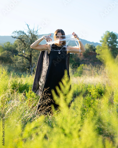 Принти на полотні Woman Holding Web-Like Material in Field