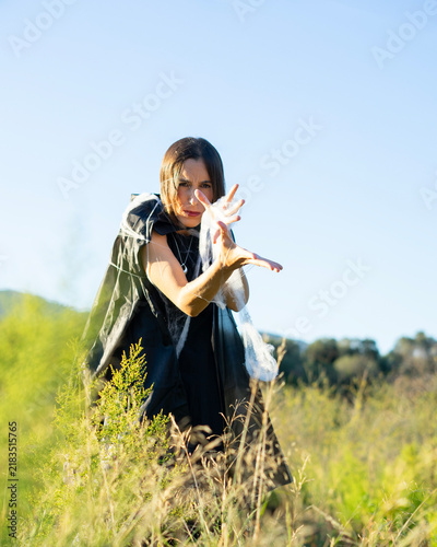Fotografie Woman Casting Magic Spell in Sunny Field
