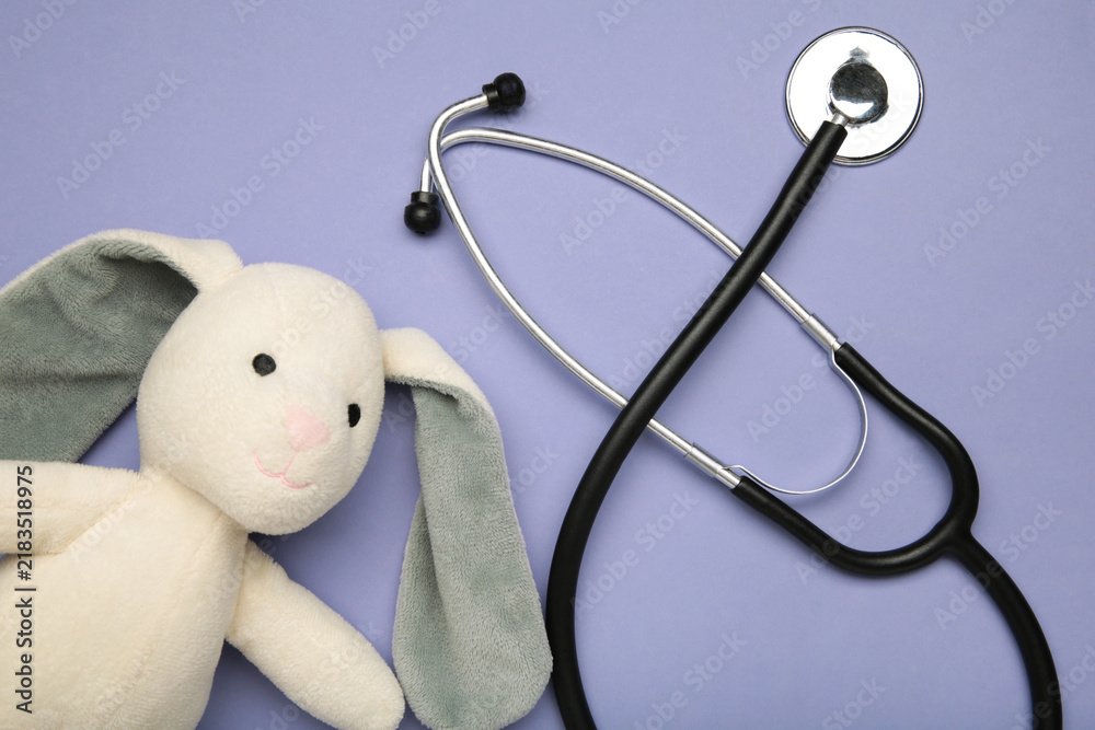 Obraz premium Pediatrician concept. Toy bunny and stethoscope on purple background.