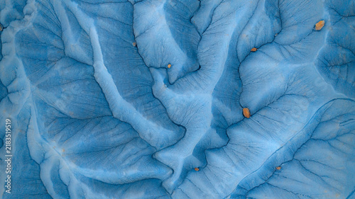 Aerial view of the intricate blue-toned eroded landscape and drainage patterns of Factory Butte in Wayne County, Utah, United States.