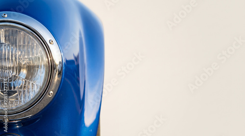 Vintage car headlight with chrome detail on a blue body  